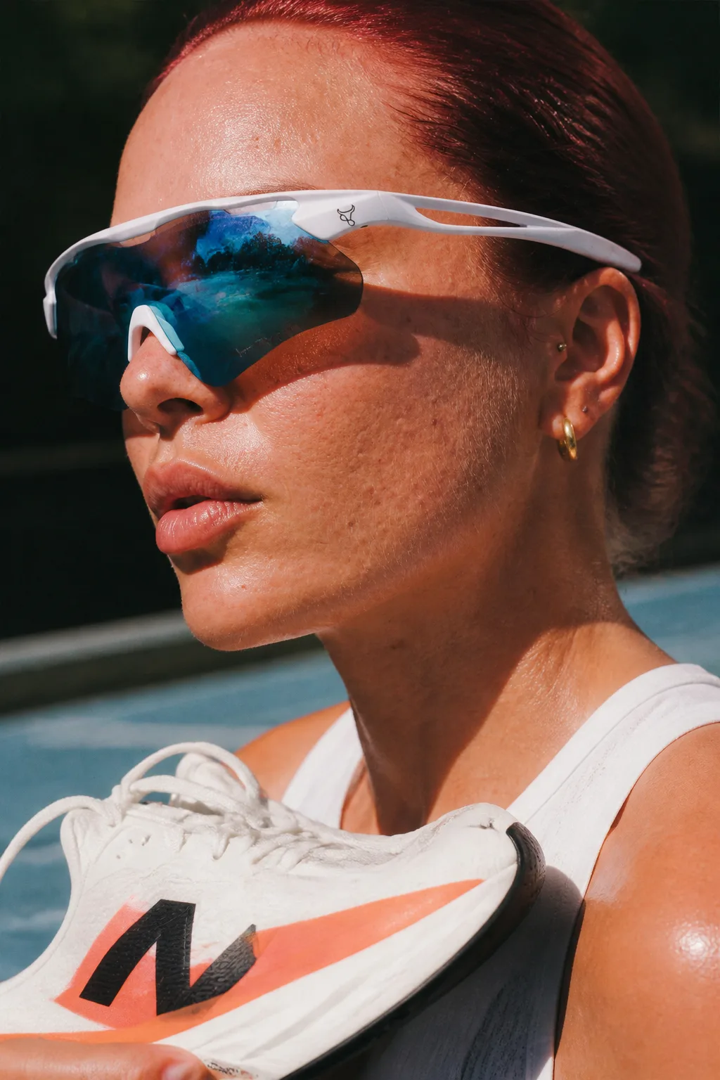 Ritratto ravvicinato di una runner con occhiali sportivi e scarpa in primo piano